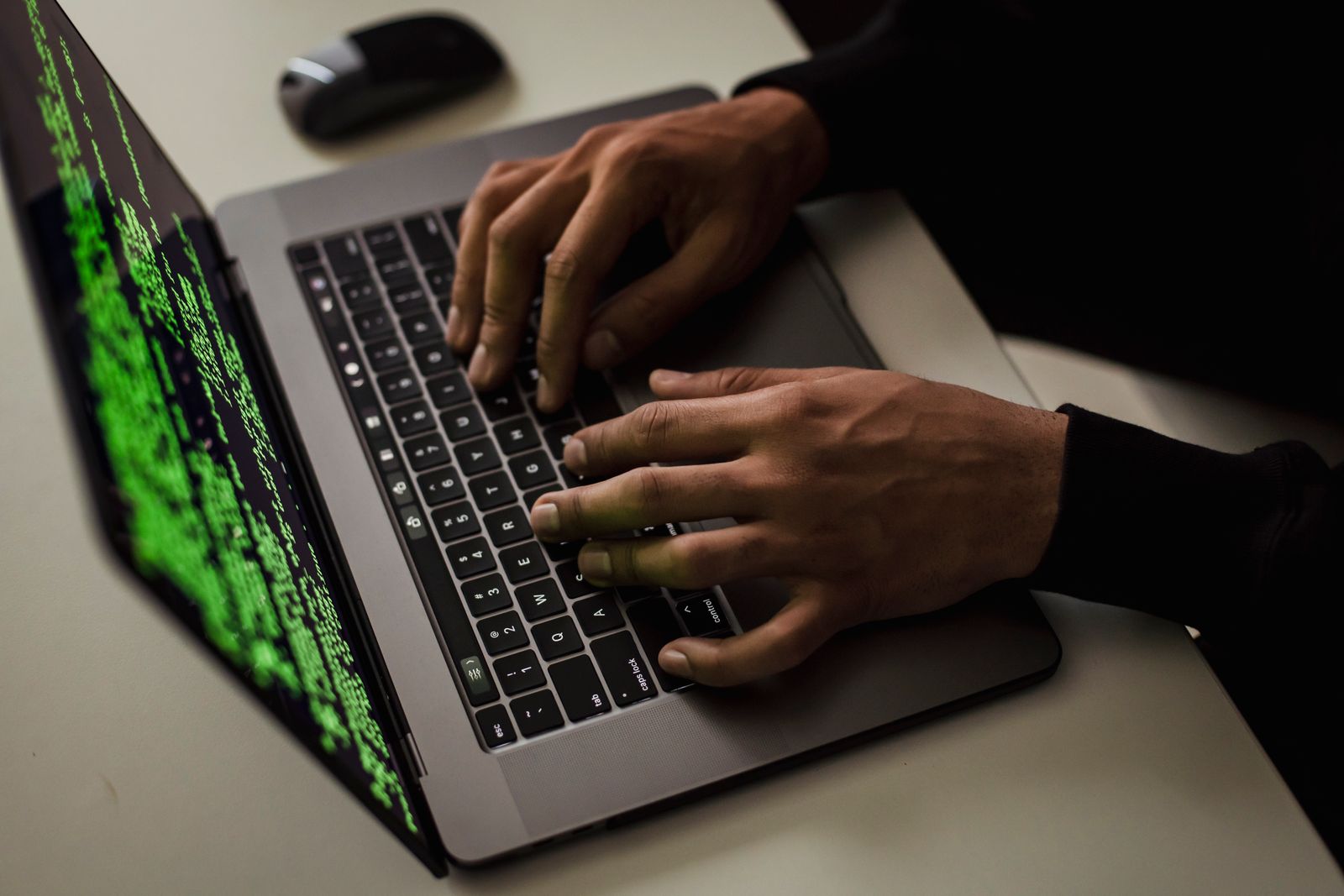 Kéz gépel egy laptopon, a képernyőn futó kód: a támadások többsége automata